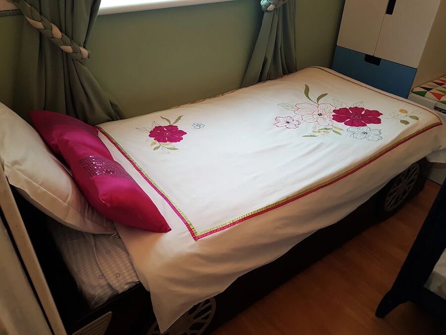 A quiet room with a small bed and a travel cot for resting.