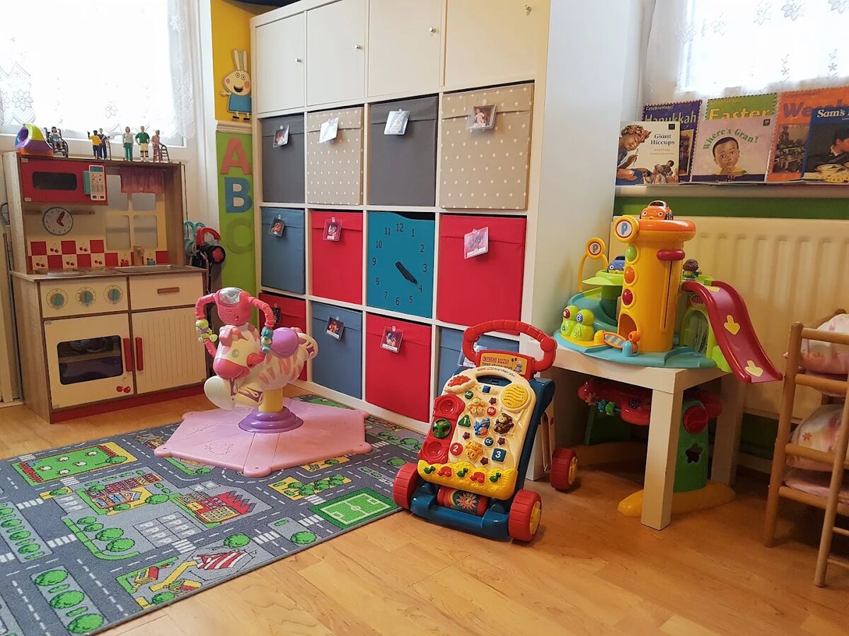The playroom with a road-map rug, ride-on toys and a play kitchen.